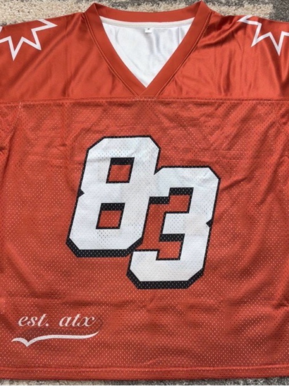 Orange Athletic Jersey with White '83' Graphic. ATX bound?